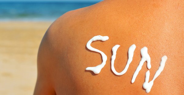sunscreen placed upon a person's back to say sun