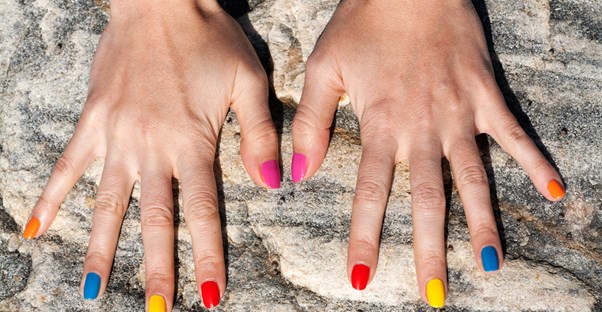 a woman shows off her multicolored nails