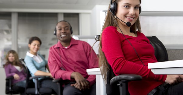 Men and women smiling while working working through call center software