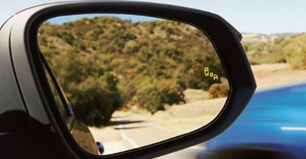 a car with blind spot monitoring in the mirror