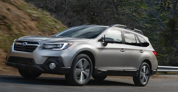 a gray 2018 subaru outback travels down the road