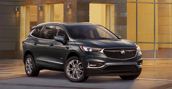 a black 2018 buick enclave in the driveway of a modern house