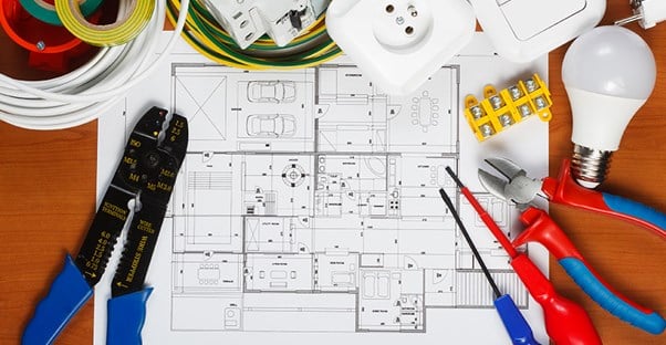 An electrician looks over a blueprint