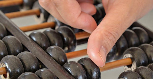 Hand counting rings on an abacus. Actuary salary. 