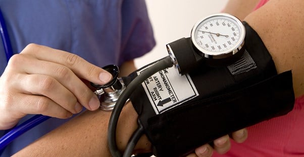 A nurse practitioner takes a patients blood pressure and thinks about the disadvantages of her job .