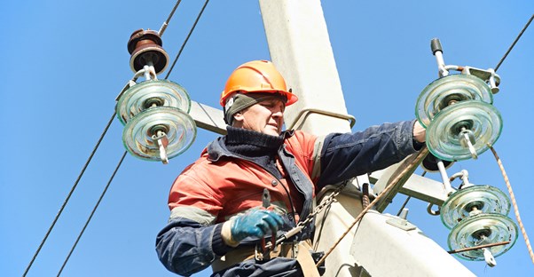 Electrician fixes broken wires on pole