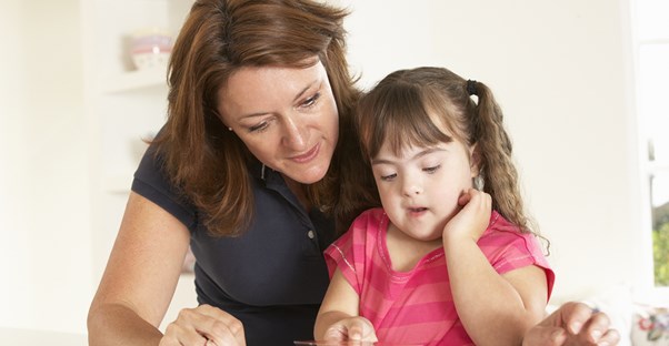 A speech pathologist works with a young girl