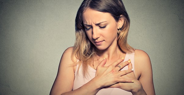 Woman holding her heart in pain