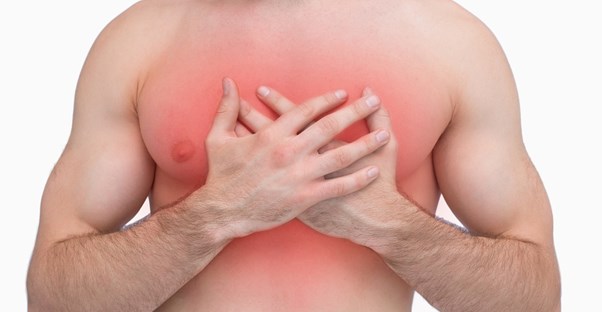 a man holds his chest in pain