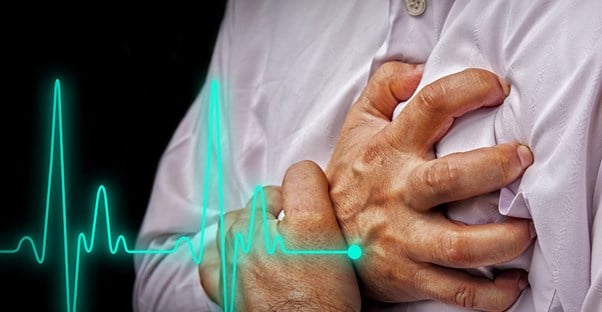 man clutching his chest because he has mitral valve prolapse