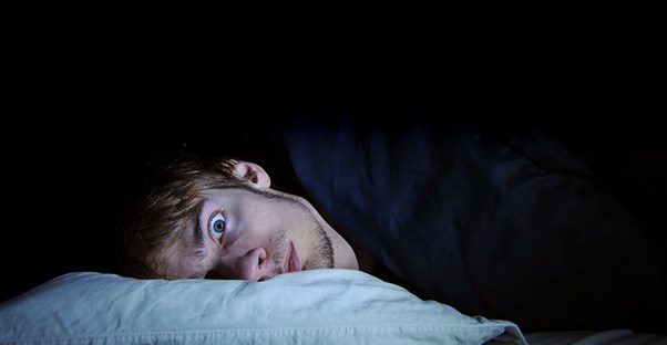 guy laying in bed experiencing night terrors