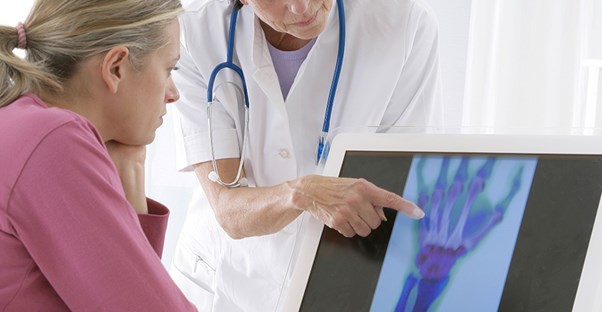woman and doctor looking at x-ray of hand and discussing arthritis treatments