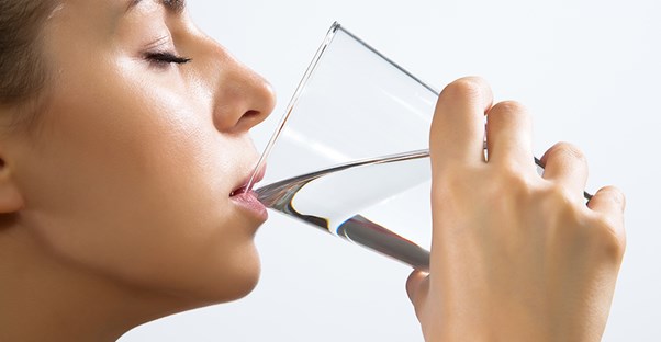 woman drinking water because she has dry mouth