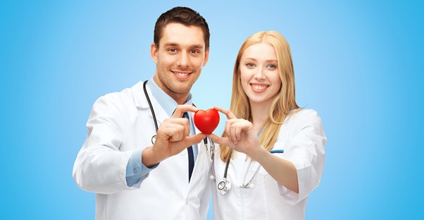 two doctors hold a plastic heart in honor of heart disease