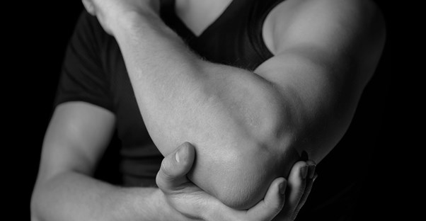 a man holds his elbow suffering from join pain