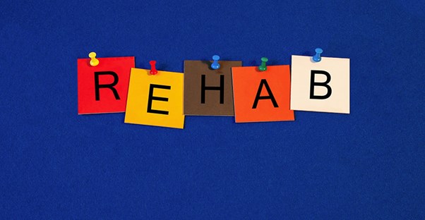 Post-its with letters form the word REHAB.