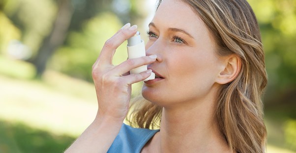 a woman using an inhaler to treat her COPD symptoms