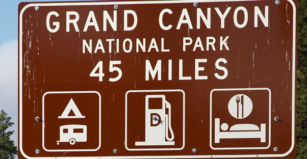 a brown road sign stating that the Grand Canyon is 45 miles away