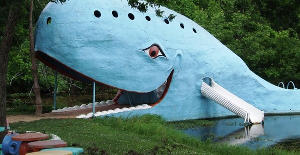 a blue whale-shaped bridge across a pond along route 66