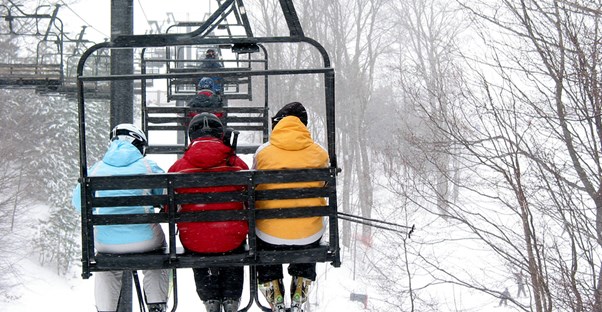 skiers ride the chair lifts up the slope to begin their run