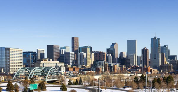 the Denver skyline with many tall building is covered in light snow