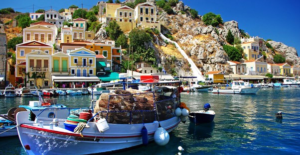 a boat sits in the colorful harbor of a greek island community