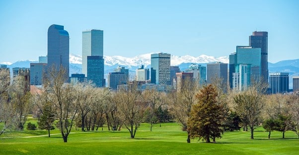 a city park serves as the foreground to the Denver skyline