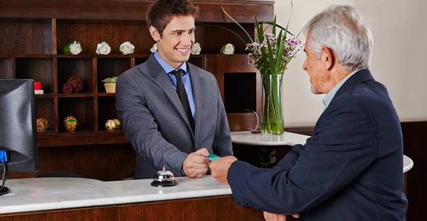 A hospitality manager gives a man his key card
