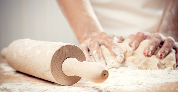 A baker kneeds dough