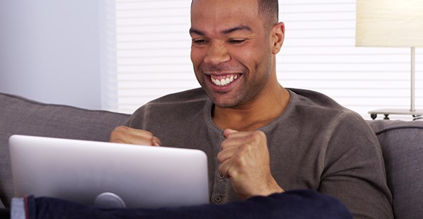 Excited man looking at laptop