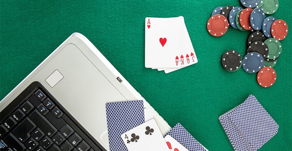 Laptop computer with playing cards and poker chips
