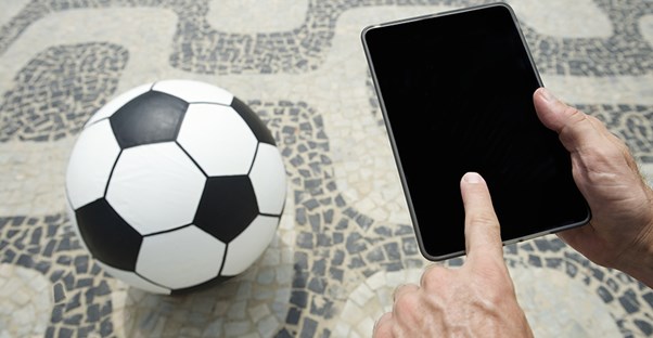 Man with soccer ball and computer tablet