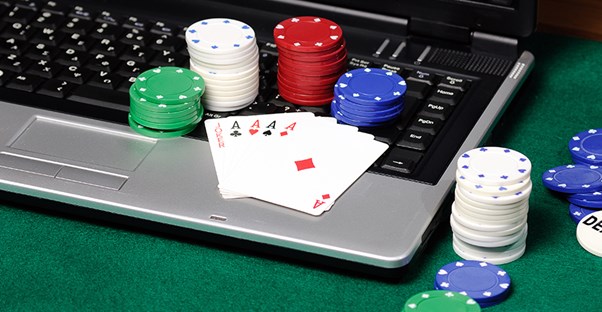 Cards and poker chips on a laptop