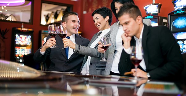 People at a casino toasting and one man looking forlorn