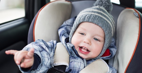 Little boy smiling because he was switched to a forward facing car seat