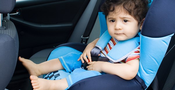 A baby boy sitting in the safest car seat available