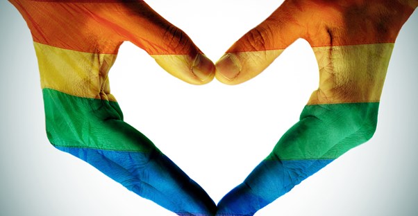 Hands forming a heart and painted a rainbow for LGBTQ.