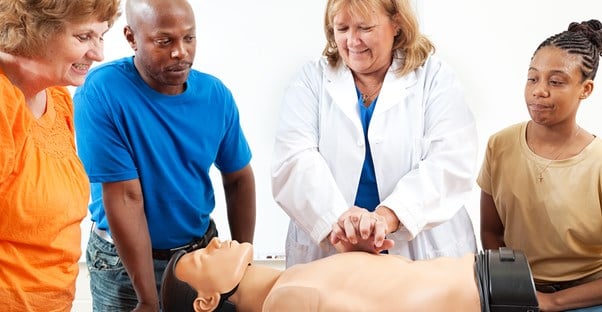 A group of aspiring EMTs practice on a dummy