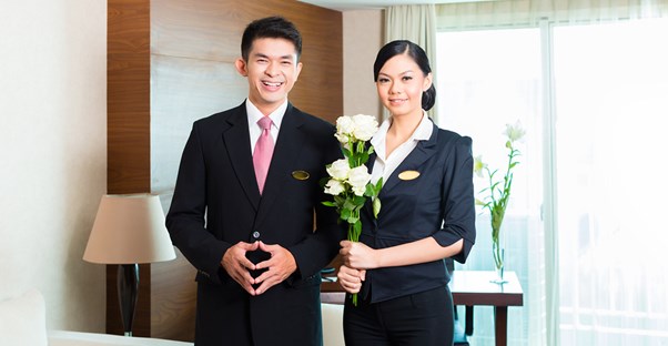 Hospitality managers bring flowers to a hotel room