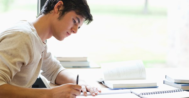 A young summer school student works on his homework