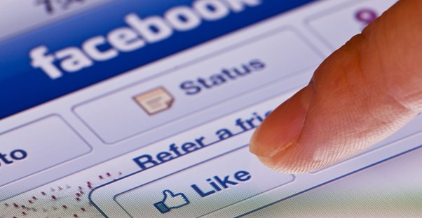 Finger pressing a button on the Facebook screen