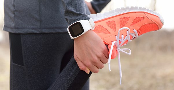 A woman runs with a fitness watch