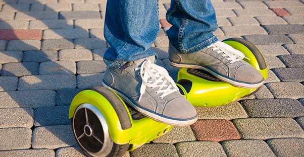 A youth rides a lime green hoverboard.