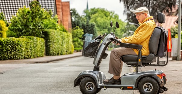 Elderly man driving a mobility scooter