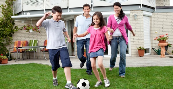 a family plays soccer together in the backyard