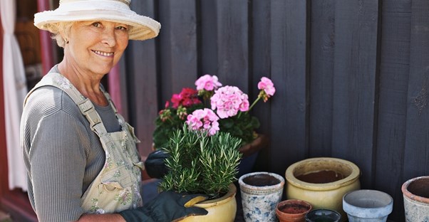 a woman enjoys planting plants in pots for her cost-effective garden
