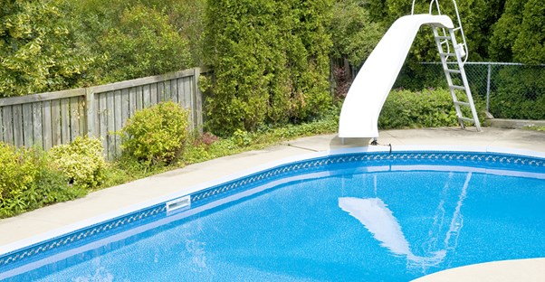 a backyard pool with a slide that may not be worth the investment