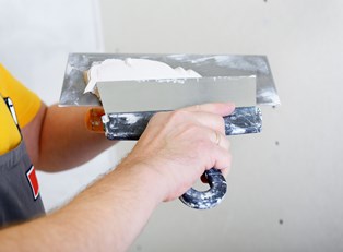 A homeowner prepares to lay tile for his bathroom remodel.