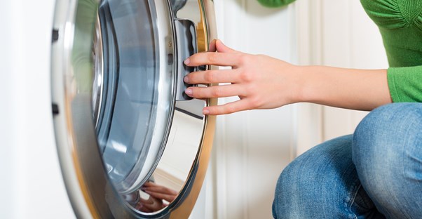 Woman cleaning a washing machine