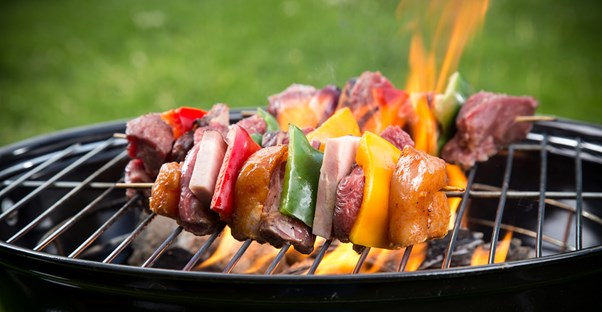 A group of skewers cooking on a grill